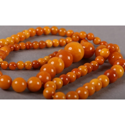 181 - AN EARLY 20TH CENTURY AMBER NECKLACE of graduated spherical beads, approximate maximum diameter 16mm... 