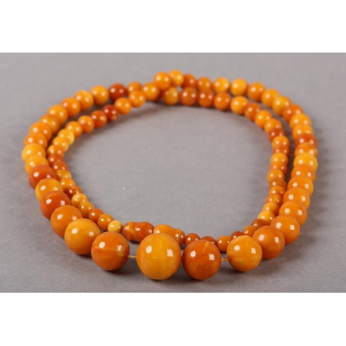 181 - AN EARLY 20TH CENTURY AMBER NECKLACE of graduated spherical beads, approximate maximum diameter 16mm... 