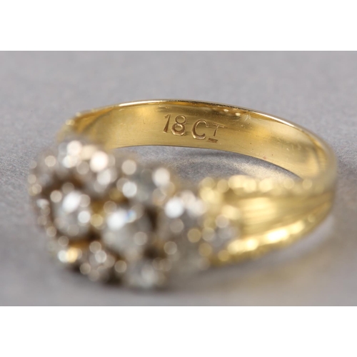 189 - A VICTORIAN DIAMOND CLUSTER RING in 18ct gold, the old European cut stones claw set within a pierced... 