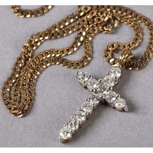 190 - A DIAMOND SET CROSS in 9ct gold, the brilliant cut stones claw set, hung from a faceted curb link ch... 