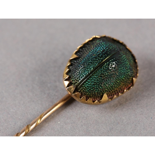 193 - A VICTORIAN SCARAB STICK PIN IN 9CT GOLD,  the iridescent carapace claw set with spiral twist pin, a... 