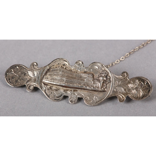 196 - A VICTORIAN SILVER BROOCH WITH AN IMAGE OF THE CRYSTAL PALACE in half relief applied to the scallope... 