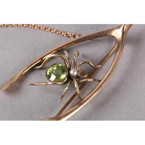 197 - AN EDWARD VII PERIDOT AND PEARL SPIDER WISHBONE BROOCH in 9ct rose gold, collet set to the abdomen w... 