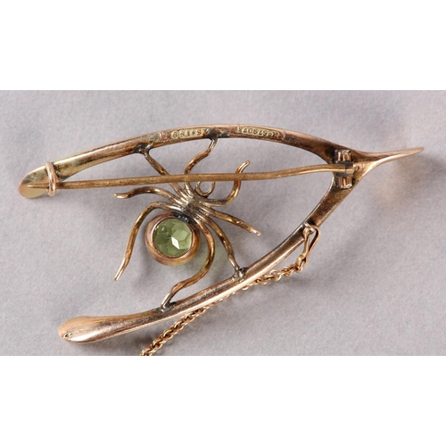 197 - AN EDWARD VII PERIDOT AND PEARL SPIDER WISHBONE BROOCH in 9ct rose gold, collet set to the abdomen w... 