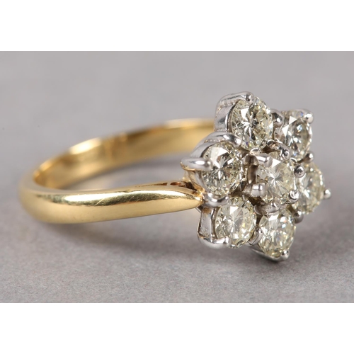 198 - A DIAMOND CLUSTER RING in 18ct yellow and white gold, the brilliant cut stones claw set within a cir... 