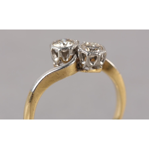 210 - A TWO STONE DIAMOND RING C1950 in 18ct gold and platinum, the brilliant cut stones illusion set in a... 