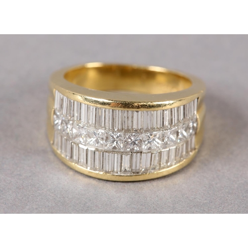 170 - A DIAMOND SET RING in 18ct gold, the graduated baguette and princess cut stones pave set flanked by ... 