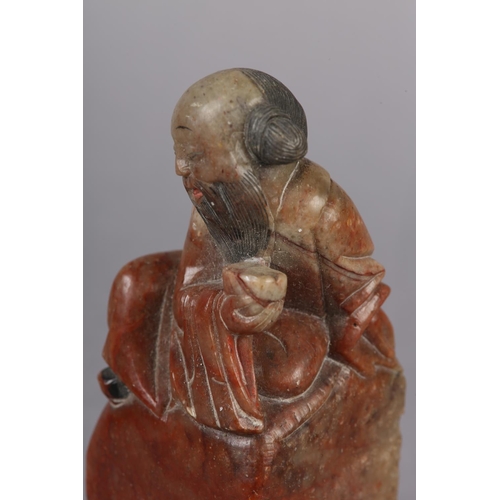 111 - A CHINESE CARVED MARBLE FIGURE OF SHOU LAO, God of longevity sitting with peach and cup, raised on a... 