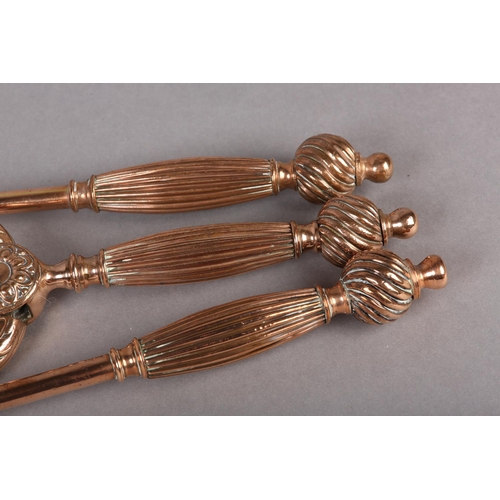 45 - A MID TO LATE 19TH CENTURY SET OF THREE COPPER FIRE IRONS, each having swollen reeded handle and wry... 