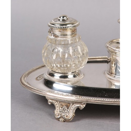 148 - AN ELKINGTON AND CO SILVER PLATED DESK STANDISH of oval outline, fitted with a chamberstick flanked ... 