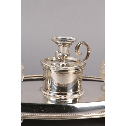 148 - AN ELKINGTON AND CO SILVER PLATED DESK STANDISH of oval outline, fitted with a chamberstick flanked ... 