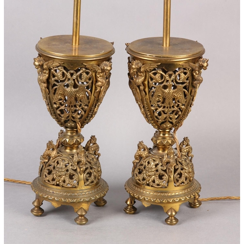 11 - A PAIR OF LATE VICTORIAN GILT METAL TABLE LAMPS, the pierced basket body having four panels cast wit... 