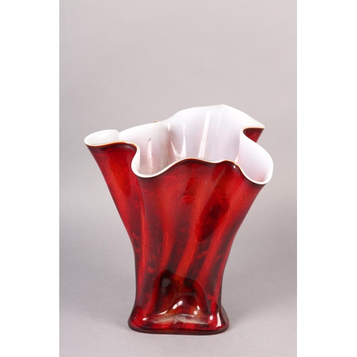 145 - A GLASS VASE OF FAZZOLETTO FORM the exterior in reds and oranges with white interior, the glass pinc... 