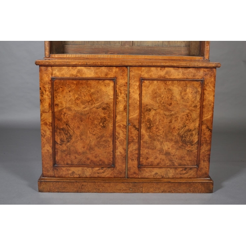 364 - A MID-19TH CENTURY FIGURED WALNUT BOOKCASE-CUPBOARD, having a moulded cornice above three open shelv... 