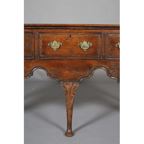 425 - AN 18th CENTURY-STYLE OAK DRESSER BASE, having three field-panelled drawers across with brass plates... 