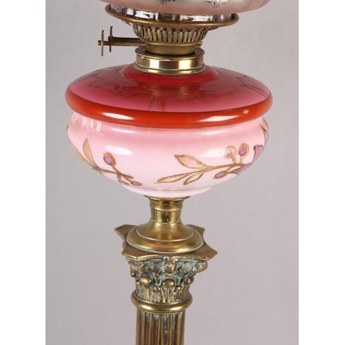 17 - A VICTORIAN BRASS CORINTHIAN COLUMN OIL LAMP, pink tinted and gilt floral reservoir, on stepped squa... 