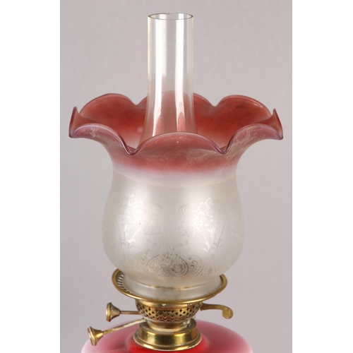 19 - A VICTORIAN BRASS OIL LAMP, the pink tinted glass reservoir painted with Gaelic harp and shamrock, o... 