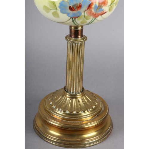 22 - A VICTORIAN BRASS REEDED COLUMN OIL LAMP, the tinted yellow glass reservoir painted with flowers, on... 