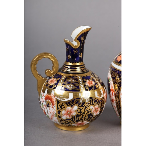 99 - A PAIR OF ROYAL CROWN DERBY IMARI PATTERN EWERS with moulded gilt handles together with a pair of wa... 