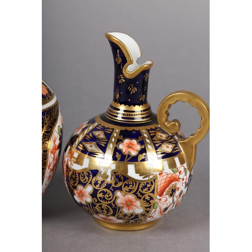 99 - A PAIR OF ROYAL CROWN DERBY IMARI PATTERN EWERS with moulded gilt handles together with a pair of wa... 