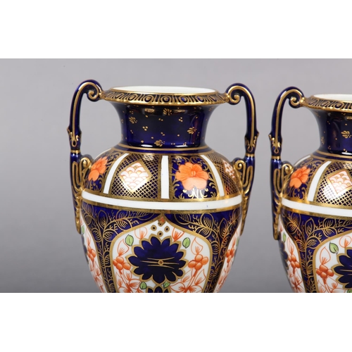 100 - A PAIR OF ROYAL CROWN DERBY IMARI PATTERN urn vases with date cyphers for 1925 together with a lidde... 