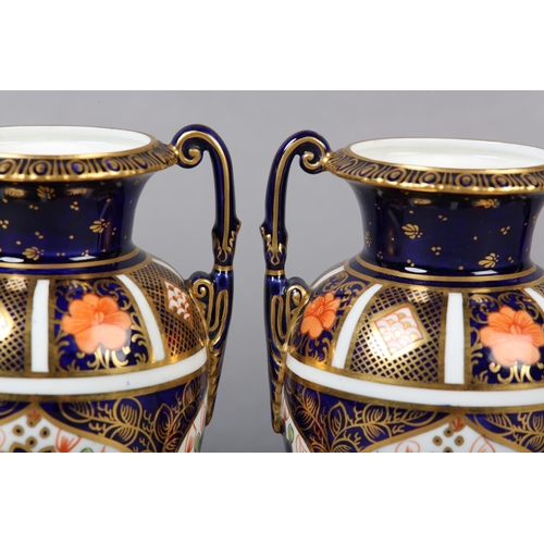 100 - A PAIR OF ROYAL CROWN DERBY IMARI PATTERN urn vases with date cyphers for 1925 together with a lidde... 