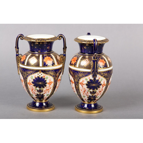 100 - A PAIR OF ROYAL CROWN DERBY IMARI PATTERN urn vases with date cyphers for 1925 together with a lidde... 