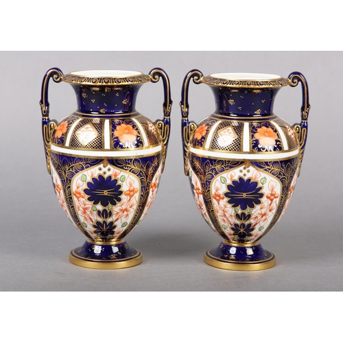 100 - A PAIR OF ROYAL CROWN DERBY IMARI PATTERN urn vases with date cyphers for 1925 together with a lidde... 