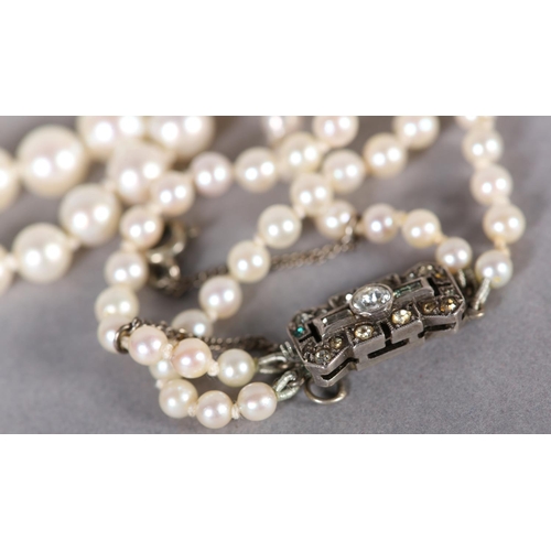 237 - A CULTURED PEARL TWO ROW NECKLACE, the graduated pearls fastened with a silver and colourless foil b... 