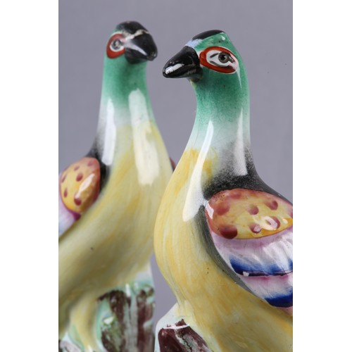 94 - A PAIR OF MID-19TH CENTURY STAFFORDSHIRE BIRDS WITH MULTICOLOURED PLUMAGE, perched on a rocky outcro... 