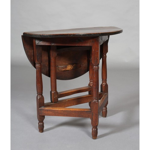 427 - A SMALL 18TH CENTURY OAK GATELEG TABLE, circular with single drop leaf, an turned and square framing... 