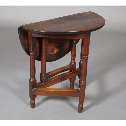 427 - A SMALL 18TH CENTURY OAK GATELEG TABLE, circular with single drop leaf, an turned and square framing... 