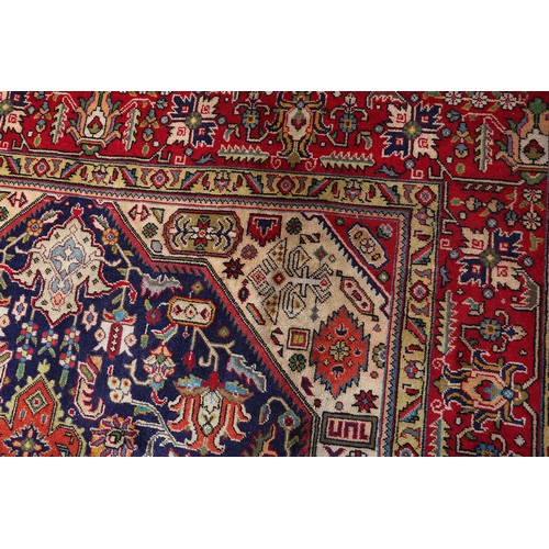 A MIDDLE EASTERN CARPET, Persian, the blue field filled with plant ...