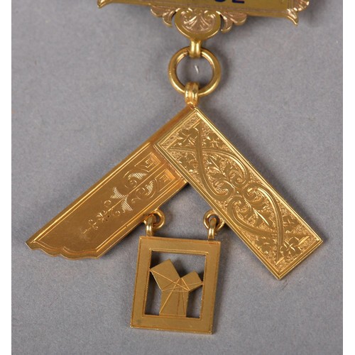 166 - A MASONIC MASTER'S JEWEL in 9ct gold, the square foliate engraved and suspended from blue enamelled ... 