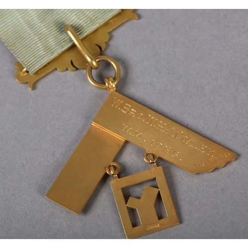 166 - A MASONIC MASTER'S JEWEL in 9ct gold, the square foliate engraved and suspended from blue enamelled ... 