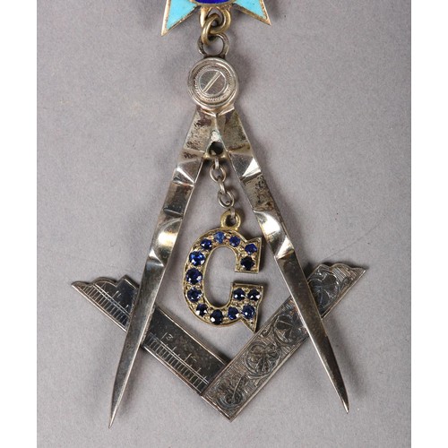 167 - A MASONIC MASTERS JEWEL in sapphire set silver, the square and compass with pendant stone set G belo... 