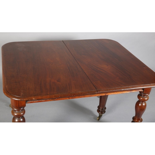 407 - A VICTORIAN MAHOGANY EXTENDING DINING TABLE, to seat eight, moulded rim, on turned legs with brass c... 