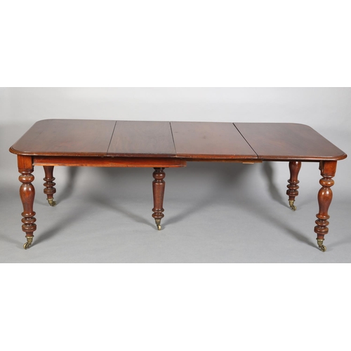 407 - A VICTORIAN MAHOGANY EXTENDING DINING TABLE, to seat eight, moulded rim, on turned legs with brass c... 