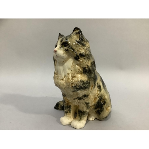 29 - A pottery figure of a tabby cat by Jenny Winstanley with glass eyes, signed to base, 24cm high