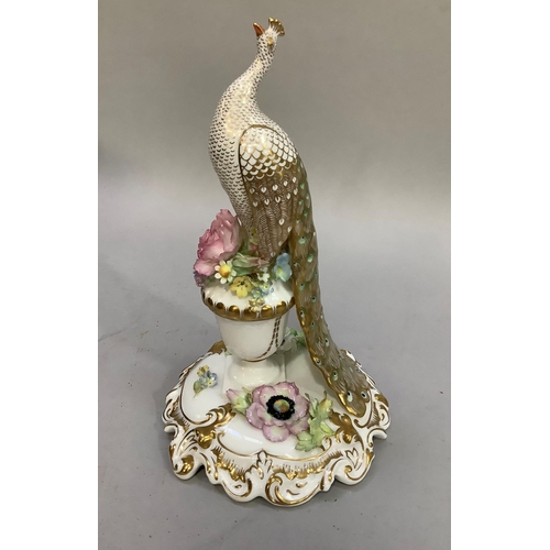 4 - A Royal Crown Derby figure of a peacock perched on a flower filled vase and shaped base, in original... 