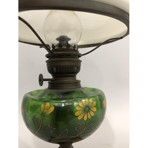 129 - Edwardian oil lamp on an Art Nouveau style pierced metal base, the green glass reservoir painted wit... 