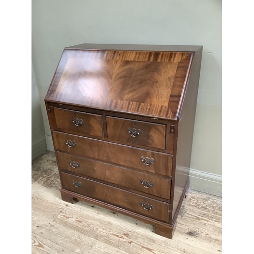 70 - A reproduction mahogany veneered bureau with drop down compartment the lid inlaid with leather inset... 