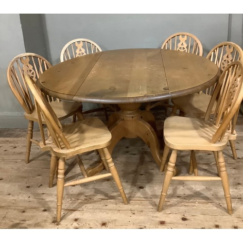 119 - A pine drop leaf circular dining table with baluster support and six kitchen dining chairs