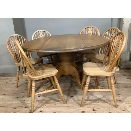 119 - A pine drop leaf circular dining table with baluster support and six kitchen dining chairs