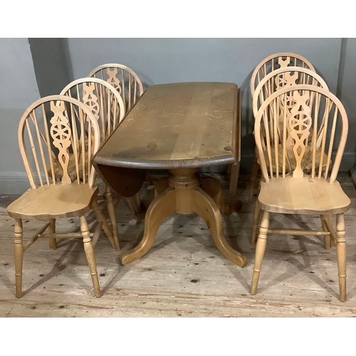 119 - A pine drop leaf circular dining table with baluster support and six kitchen dining chairs