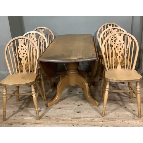 119 - A pine drop leaf circular dining table with baluster support and six kitchen dining chairs