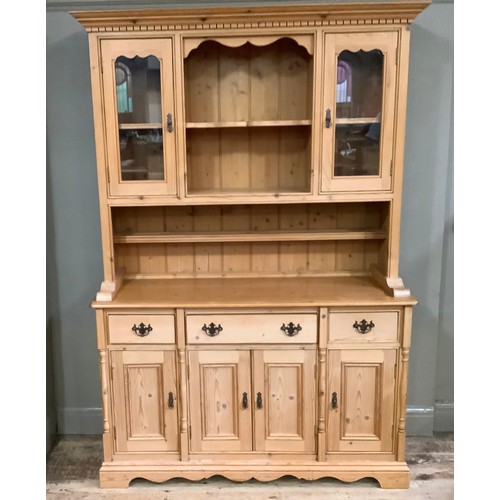 233 - A pine sideboard having two glazed doors above a base of three drawers above three doors