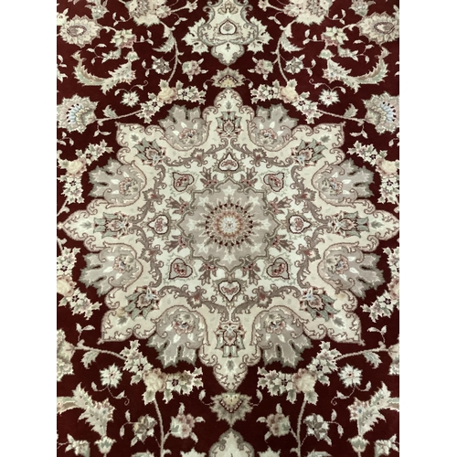 237 - A Turkish wool on cotton hand woven Durude rug, the wine field having an ivory rosette medallion and... 