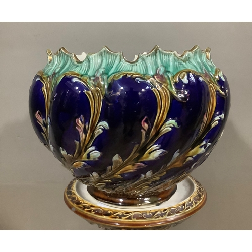 238 - A late Victorian pottery jardiniere and stand of writhern moulding, dark blue ground moulded and det... 