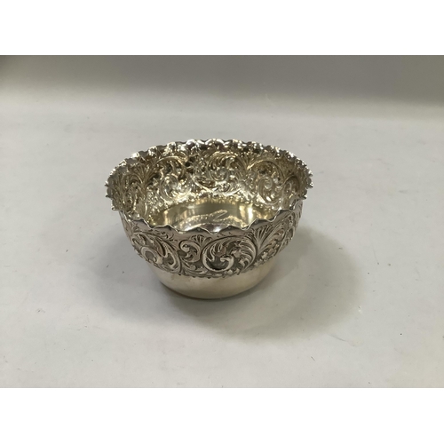 285 - A silver bowl, circular having a folded rim above a deep border embossed with leaf curls, monogramme... 